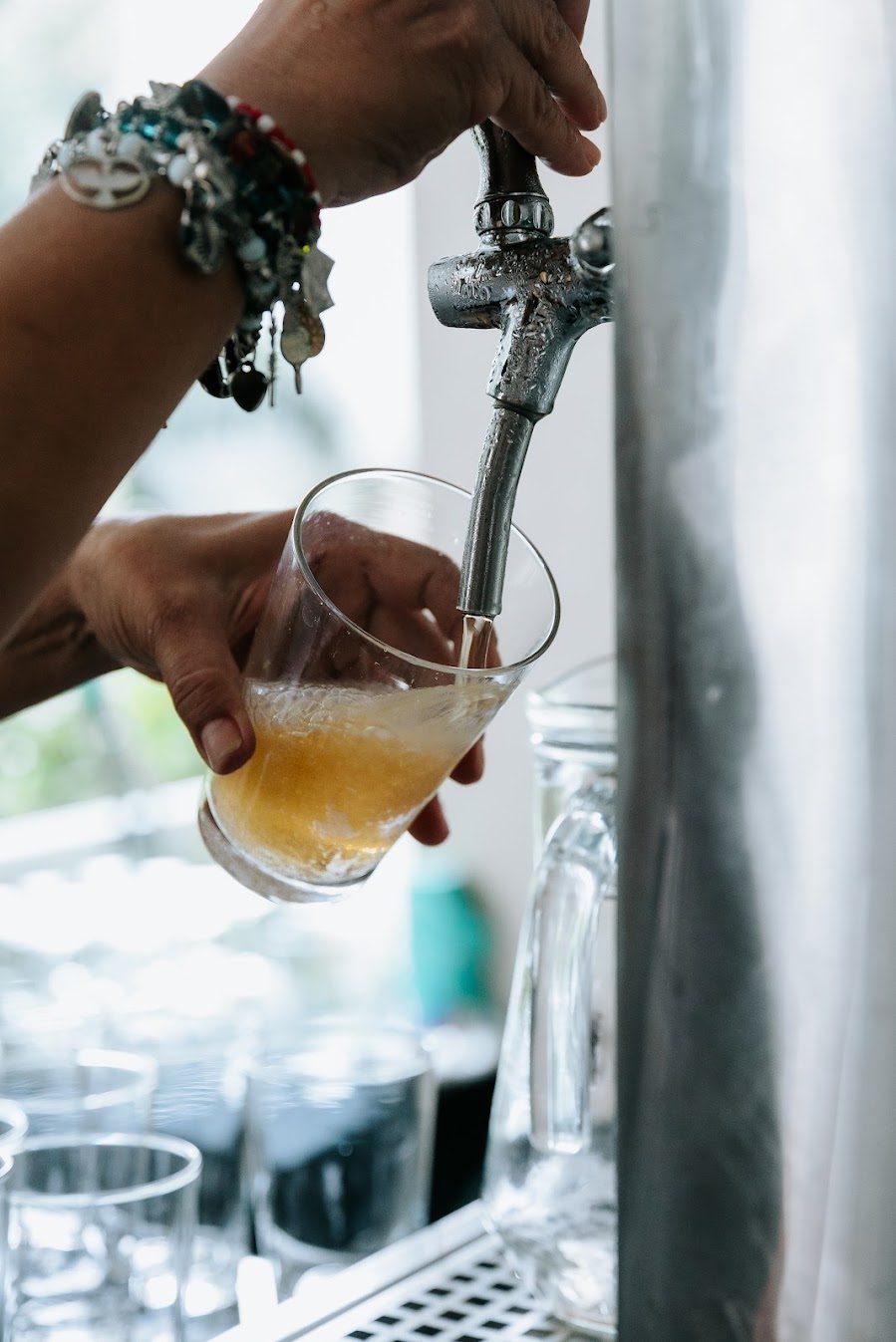 Chopp sendo servido na torneira em copo de vidro durante evento