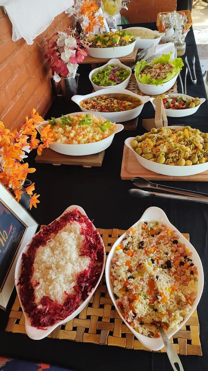 Mesa decorada com variedade de saladas, arroz e acompanhamentos